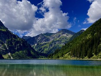 Scenic view of lake by mountains against sky