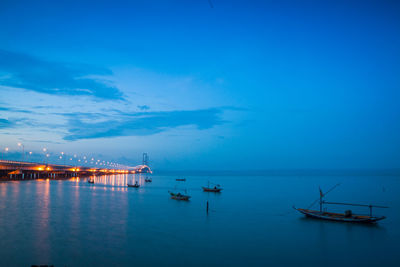 Boats moored on sea against blue sky