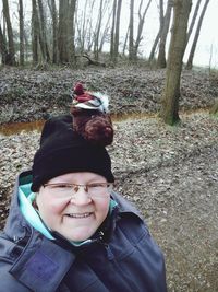 Portrait of happy man sitting on tree trunk