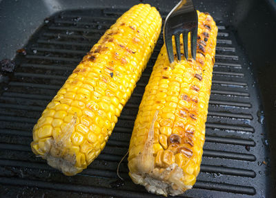 Close-up of sweetcorns cooking on barbecue grill