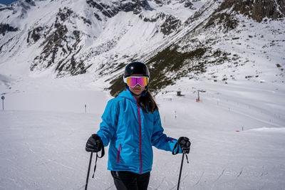 Young women with ski goggles in tirol in blue ski jacket and helmet