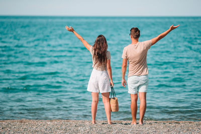 Rear view of women standing on beach