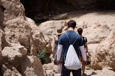 Rear view of man standing against rocks