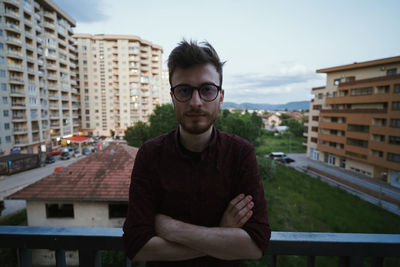 Portrait of young man standing in city