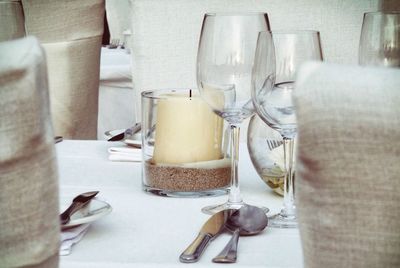 Close-up of tea light candles and wine glasses on table