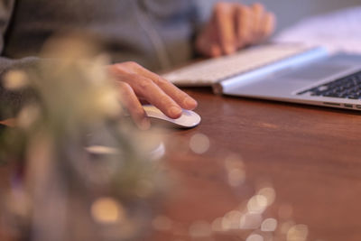 Midsection of man using mobile phone on table