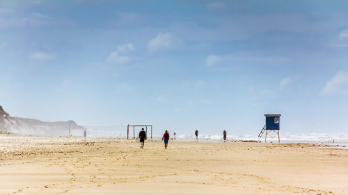 People on beach against sky