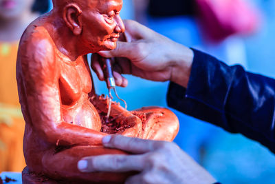 Cropped image of sculptor carving statue