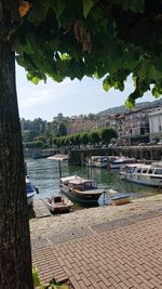 Boats moored in river against sky