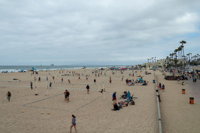 Group of people at beach against sky