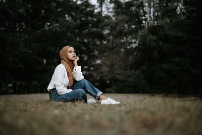 Full length of woman sitting on field