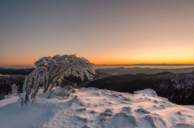 Scenic view of snowcapped mountain against sky during sunset