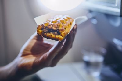 Cropped hand having food in airplane