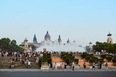 Group of people in front of historic building against clear sky