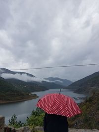 Rear view of woman by mountain against sky