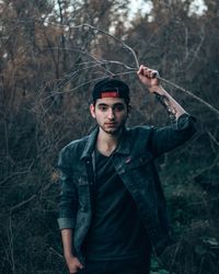 Portrait of young man standing in forest