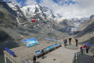 Tourists at observation point against mountains during winter