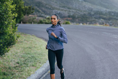 Portrait of young woman walking on road