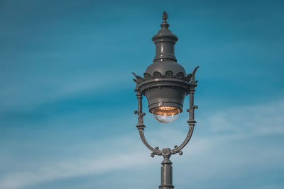 Low angle view of street light against blue sky