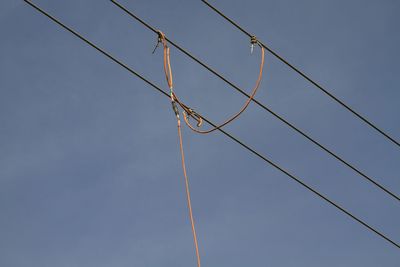 Low angle view of power lines against sky