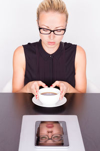 Beautiful woman sitting at cafe with coffee on table