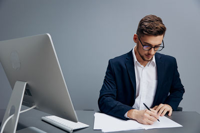 Side view of businessman using laptop at office