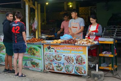 Full length of friends standing at market