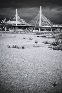 Bridge over snow covered field against sky