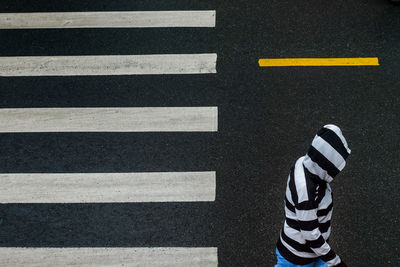 Low section of man crossing road