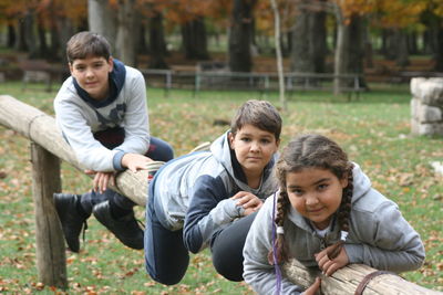 Portrait of siblings sitting on field
