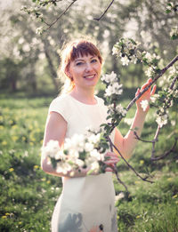 Young woman portrait on the blooming apple trees background