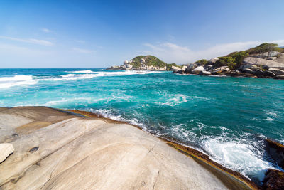 Rock formations in sea against sky at tayrona national park