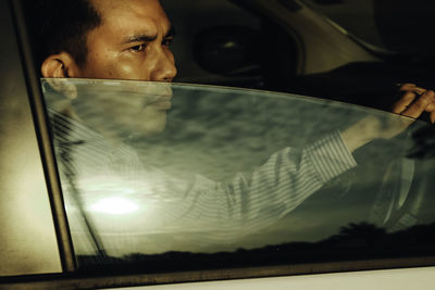 Man looking away while sitting in car