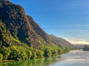 Scenic view of lake by mountain against sky