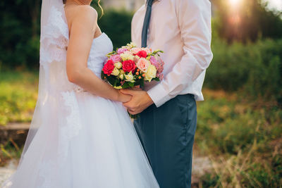 Midsection of woman holding flower bouquet