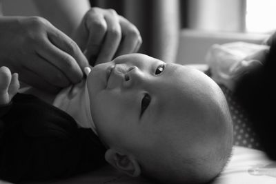 Close-up of mother dressing baby at home