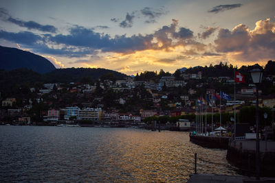 Scenic view of townscape by sea against sky during sunset