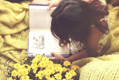 Close-up of girl with flowers on bed