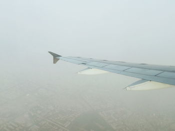 Aerial view of airplane wing against clear sky