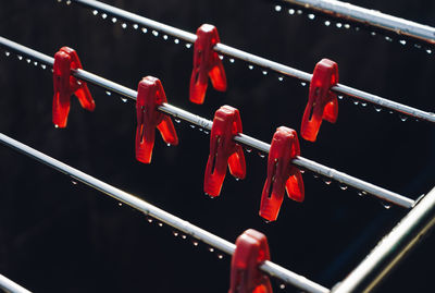 Clothespins hanging on wet metallic rod