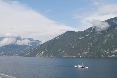 Scenic view of sea by mountains against sky