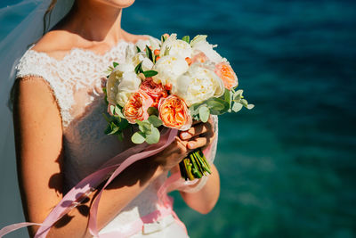 Midsection of woman holding flower bouquet