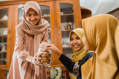 Woman offering snack to guests at home