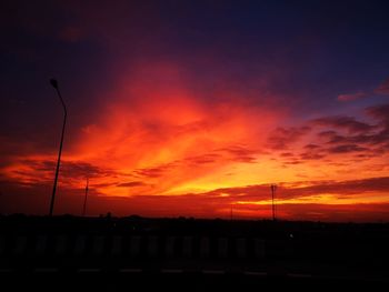 Silhouette landscape against dramatic sky during sunset