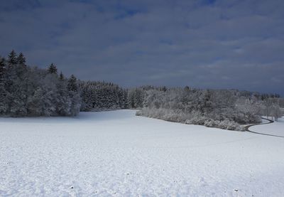 Snow covered field against sky