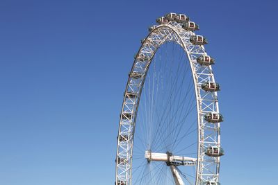 Low angle view of the london eye against clear blue sky