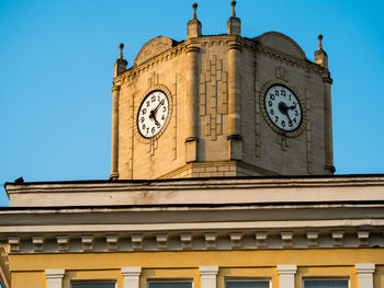 Low angle view of clock tower against blue sky