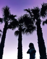 Low angle view of silhouette man photographing against sky