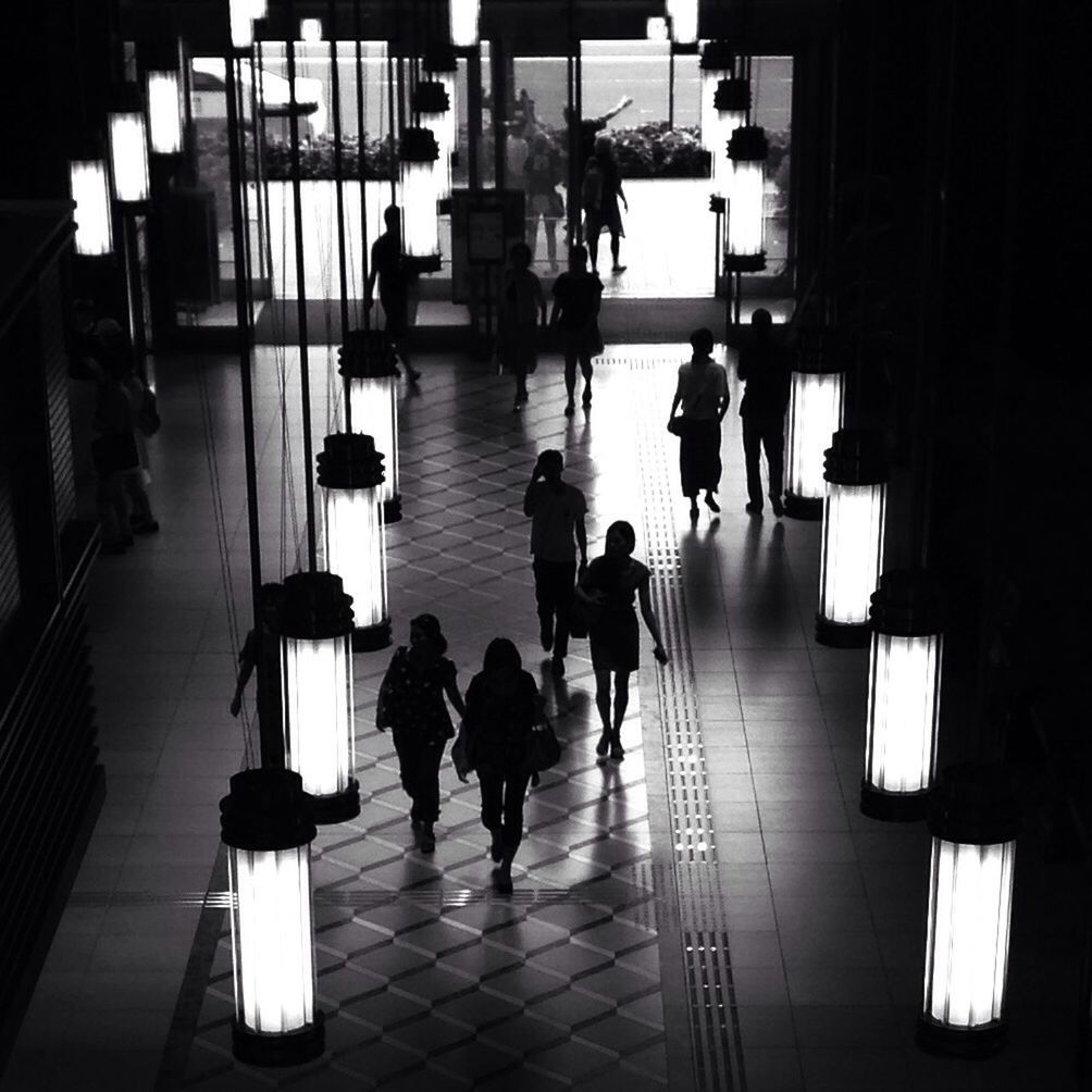 indoors, illuminated, lighting equipment, men, reflection, architecture, flooring, silhouette, tiled floor, built structure, person, lifestyles, chair, corridor, table, ceiling, railing, restaurant