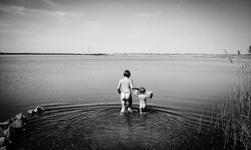 Man with dog on sea against sky